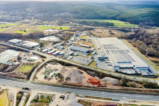 Aerial view of an industrial zone with large warehouses a quarry and railway tracks surrounded by green fields and forests in Forchheim Bavaria Germany. Aerial view of an industrial zone with large warehouses a quarry and railway tracks surrounded by green fields and forests in Forchheim Bavaria Germany.