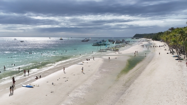 Malay Philippines 02 May 2026 Aerial view of Boracay Island with its white sand beach turquoise waters and people relaxing under a cloudy sky.