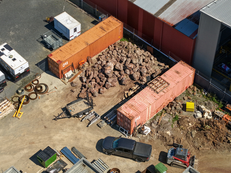Kilsyth Australia 20 September 2026 Aerial view of an industrial site featuring shipping containers large piles of rocks a parked pickup truck and construction machinery. Kilsyth Australia 20 September 2026 Aerial view of an industrial site featuring shipping containers large piles of rocks a parked pickup truck and construction machinery.