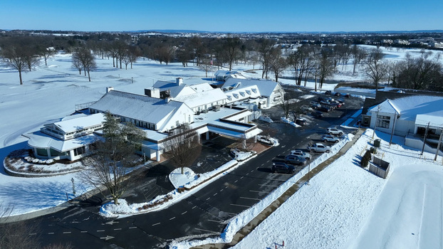 Aerial view of the snow covered New Holland Pike area featuring a large building complex with parking lots and surrounding winter landscape in Leola Pennsylvania United States.