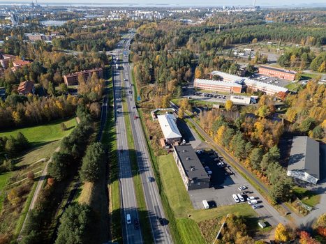 Aerial view of a traffic scene on a highway surrounded by autumn trees and buildings in Oulu North Ostrobothnia Finland. Aerial view of a traffic scene on a highway surrounded by autumn trees and buildings in Oulu North Ostrobothnia Finland.