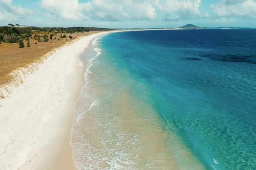 Aerial view of Puwheke Beach featuring white sand turquoise water and coastal dunes Karikari Peninsula Northland Region New Zealand.