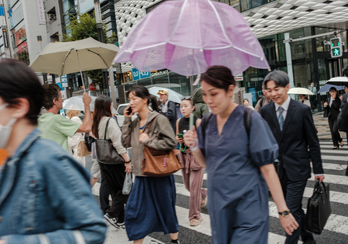 Tokyo Japan 01 October 2025 View of pedestrians traversing a crosswalk their umbrellas creating a vibrant canopy against the muted tones of the city s architecture. Tokyo Japan 01 October 2025 View of pedestrians traversing a crosswalk their umbrellas creating a vibrant canopy against the muted tones of the city s architecture.