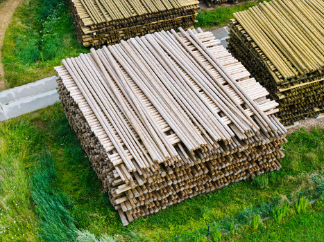 Aerial view of stacked timber logs in a sustainable forestry supply chain showcasing organized wood piles in a green field in Latvia. Aerial view of stacked timber logs in a sustainable forestry supply chain showcasing organized wood piles in a green field in Latvia.