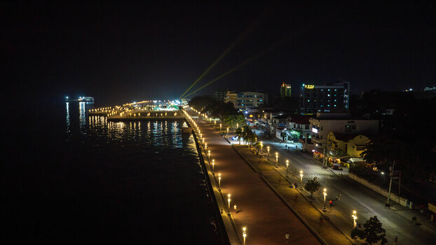 Aerial view of Rizal Boulevard at night with illuminated street lamps lining the waterfront promenade city buildings and calm sea in Dumaguete City Negros Island Region Philippines. Aerial view of Rizal Boulevard at night with illuminated street lamps lining the waterfront promenade city buildings and calm sea in Dumaguete City Negros Island Region Philippines.