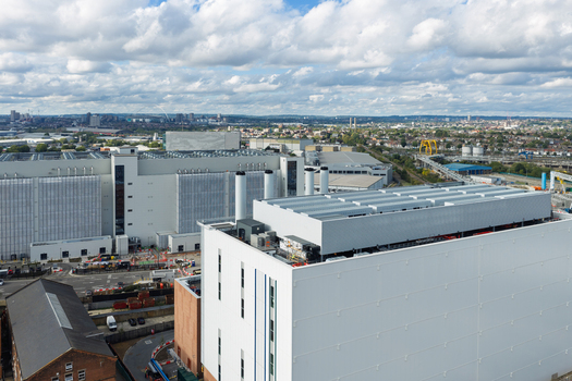 Aerial view of a modern data center facility with white industrial buildings cooling towers and infrastructure in the United Kingdom. Aerial view of a modern data center facility with white industrial buildings cooling towers and infrastructure in the United Kingdom.