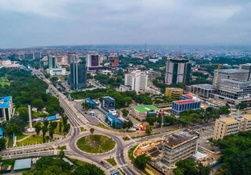 Aerial view of the modern cityscape of Accra featuring high rise buildings a large roundabout and lush green spaces in Ghana. Aerial view of the modern cityscape of Accra featuring high rise buildings a large roundabout and lush green spaces in Ghana.