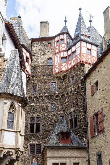 View of Eltz Castle featuring medieval stone walls half timbered architecture and pointed slate turrets in the inner courtyard Wierschem Rhineland Palatinate Germany.