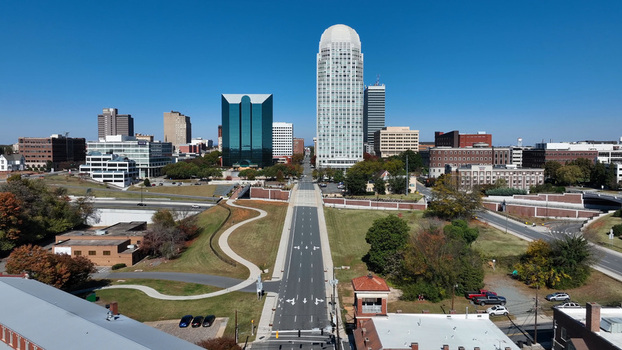 Aerial view of the Winston Salem skyline featuring the prominent Wells Fargo Center surrounded by urban buildings highways and autumn trees in Winston Salem North Carolina United States.