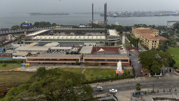 Aerial view of the Onikan Stadium and adjacent swimming pool complex with surrounding urban infrastructure and the harbor in the background in Lagos Lagos Nigeria. Aerial view of the Onikan Stadium and adjacent swimming pool complex with surrounding urban infrastructure and the harbor in the background in Lagos Lagos Nigeria.