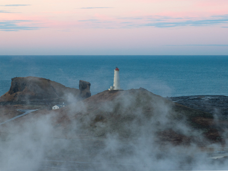 Aerial view of Reykjanes lighthouse surrounded by volcanic terrain and geothermal steam rising from the ground near the ocean in Grindavikurbaer Iceland. Aerial view of Reykjanes lighthouse surrounded by volcanic terrain and geothermal steam rising from the ground near the ocean in Grindavikurbaer Iceland.
