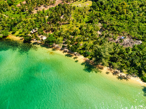 Aerial view of emerald waters gently kiss the golden sands beneath lush verdant foliage painting a picturesque coastal panorama Preah Sihanouk Sihanoukville Cambodia.