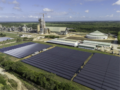 Aerial view of Cemento Panam industrial plant and adjacent solar farm with rows of photovoltaic panels under a clear sky in Los Llanos San Pedro de Macoris Dominican Republic. Aerial view of Cemento Panam industrial plant and adjacent solar farm with rows of photovoltaic panels under a clear sky in Los Llanos San Pedro de Macoris Dominican Republic.