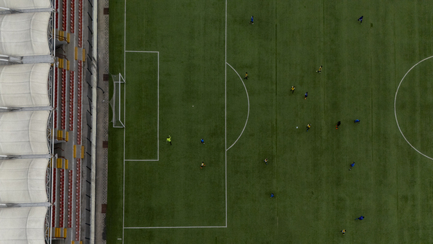 Aerial view of a soccer match in progress at a stadium with players on the green pitch and red seating in the stands in Lagos Lagos Nigeria. Aerial view of a soccer match in progress at a stadium with players on the green pitch and red seating in the stands in Lagos Lagos Nigeria.