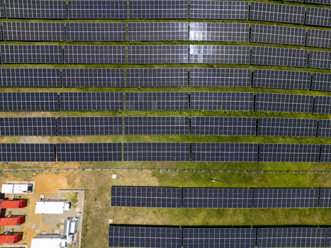 Aerial view of a large solar panel farm with rows of photovoltaic modules installed on green fields in Guanaja Bay Islands Department Honduras.