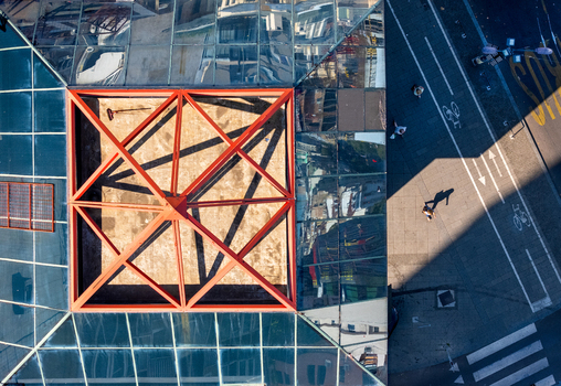 Aerial view of a building with a distinctive red framed glass roof adjacent to a city street with pedestrians and a crosswalk in Belgrade City of Belgrade Serbia. Aerial view of a building with a distinctive red framed glass roof adjacent to a city street with pedestrians and a crosswalk in Belgrade City of Belgrade Serbia.