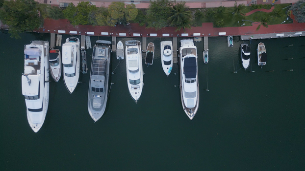 Aerial view of luxury yachts and motorboats docked at a marina in Miami Beach Florida United States. Aerial view of luxury yachts and motorboats docked at a marina in Miami Beach Florida United States.
