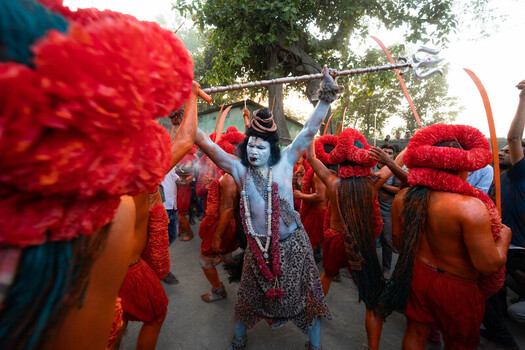 Munshiganj Bangladesh 13 April 2025 View of a vibrant religious procession with a blue painted Shiva figure amidst a sea of fiery red and orange devotees creating a striking visual spectacle. Munshiganj Bangladesh 13 April 2025 View of a vibrant religious procession with a blue painted Shiva figure amidst a sea of fiery red and orange devotees creating a striking visual spectacle.