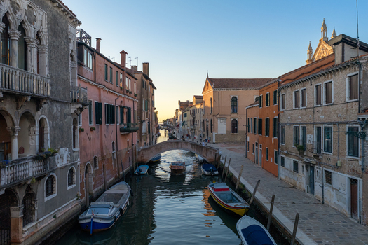 Aerial view of a canal with historic buildings a stone bridge and moored boats in Venice Veneto Italy. Aerial view of a canal with historic buildings a stone bridge and moored boats in Venice Veneto Italy.