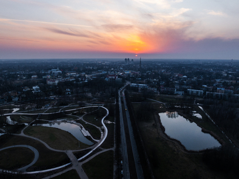 Aerial view of Uzvaras parks in Riga during a vibrant sunset featuring reflective ponds winding pathways and the surrounding urban landscape of Riga Latvia. Aerial view of Uzvaras parks in Riga during a vibrant sunset featuring reflective ponds winding pathways and the surrounding urban landscape of Riga Latvia.