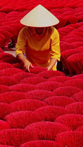 View of a person among red incense sticks Vietnam.