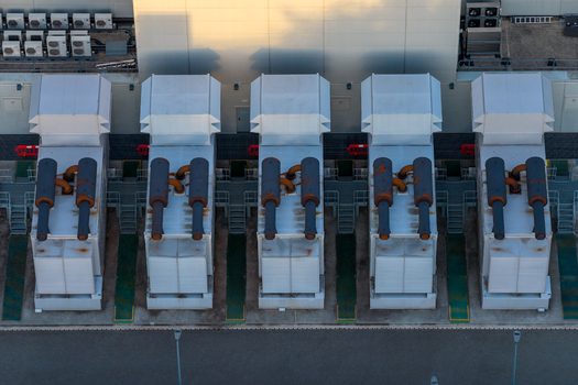 Aerial view of industrial cooling units at the Kao Data facility with metallic pipes and ventilation systems arranged in rows in Harlow England United Kingdom. Aerial view of industrial cooling units at the Kao Data facility with metallic pipes and ventilation systems arranged in rows in Harlow England United Kingdom.