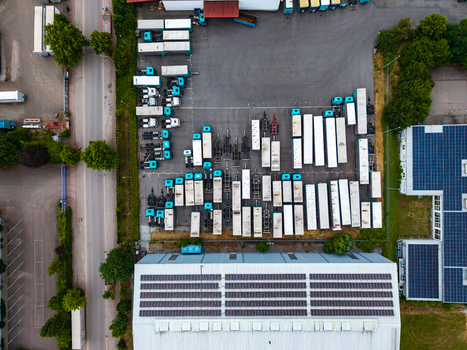 Aerial view of the Neuenstein Techno Zone featuring a large warehouse with solar panels and a parking lot filled with numerous semi truck trailers in Neuenstein Baden Wurttemberg Germany. Aerial view of the Neuenstein Techno Zone featuring a large warehouse with solar panels and a parking lot filled with numerous semi truck trailers in Neuenstein Baden Wurttemberg Germany.