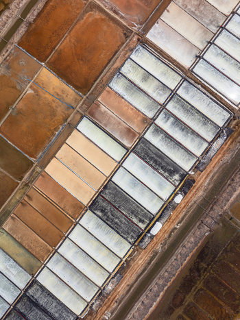 Aerial view of salt pans with rectangular pools showing varying shades of brown and white in Vietnam. Aerial view of salt pans with rectangular pools showing varying shades of brown and white in Vietnam.