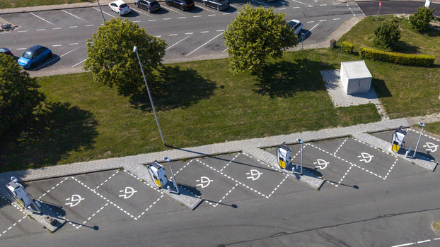 Aerial view of Shell Recharge charging station with multiple electric vehicle parking spots marked with white lines in a parking lot in Lelystad Flevoland Netherlands. Aerial view of Shell Recharge charging station with multiple electric vehicle parking spots marked with white lines in a parking lot in Lelystad Flevoland Netherlands.