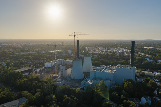 Aerial view of the Lichterfelde Power Station during deconstruction with cooling towers and construction cranes surrounded by urban greenery in Berlin Berlin Germany. Aerial view of the Lichterfelde Power Station during deconstruction with cooling towers and construction cranes surrounded by urban greenery in Berlin Berlin Germany.
