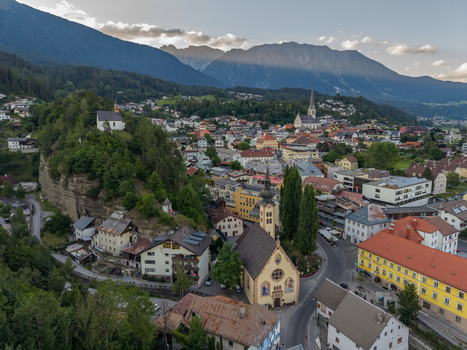 Aerial view of the historic town of Imst with its prominent church traditional alpine architecture and surrounding mountain valley landscape in Imst Tyrol Austria.