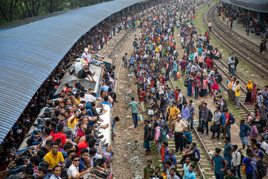 Dhaka Bangladesh 15 June 2018 View of Airport Railway Station crowded with people sitting on the train roof and standing on the tracks during a busy period. Dhaka Bangladesh 15 June 2018 View of Airport Railway Station crowded with people sitting on the train roof and standing on the tracks during a busy period.