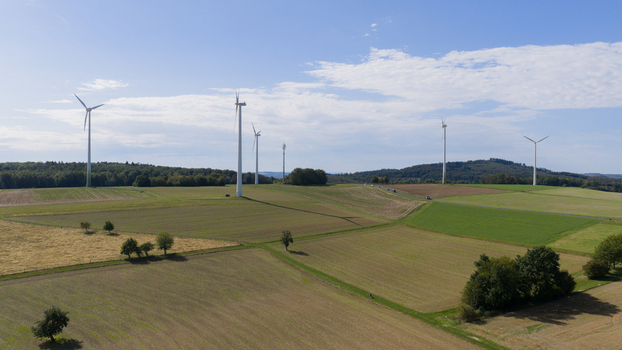 Aerial view of Windpark Eppenrod featuring wind turbines set amidst agricultural fields and rolling hills in Eppenrod Rheinland Pfalz Germany.
