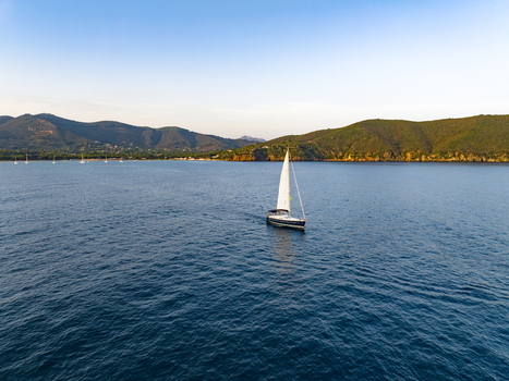 Aerial view of a sailboat sailing in the calm waters of Lacona Bay Lacona Tuscany Italy.