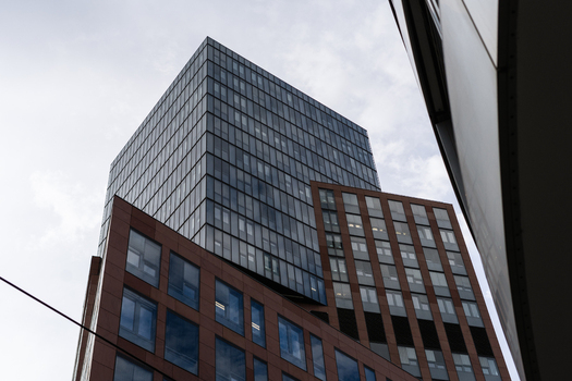 View of a modern skyscraper with a glass facade and geometric window patterns under an overcast sky in Vienna Vienna Austria. View of a modern skyscraper with a glass facade and geometric window patterns under an overcast sky in Vienna Vienna Austria.