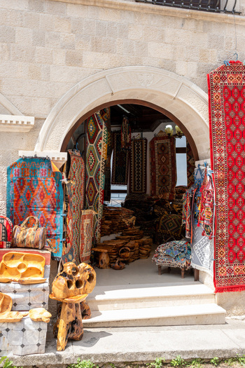 View of traditional Albanian carpets and wooden handicrafts displayed at a shop entrance in the historic bazaar in Kruje Durres County Albania.