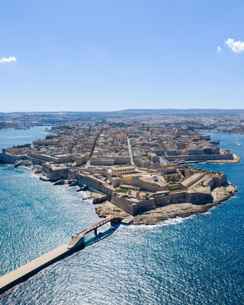 Aerial view of the historic city of Valletta with its ancient fortifications dense urban architecture and surrounding blue waters in Valletta Port Region Malta. Aerial view of the historic city of Valletta with its ancient fortifications dense urban architecture and surrounding blue waters in Valletta Port Region Malta.