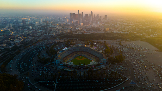Aerial view of Dodger Stadium bathed in golden light with the downtown skyline in the distance Los Angeles California United States. Aerial view of Dodger Stadium bathed in golden light with the downtown skyline in the distance Los Angeles California United States.