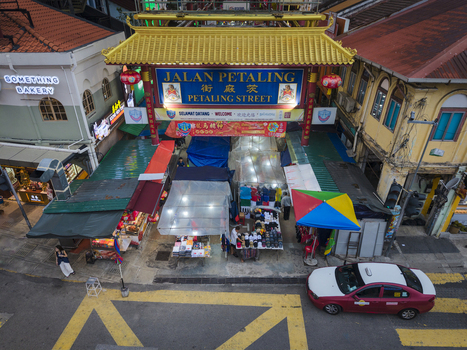 Kuala Lumpur Malaysia 09 March 2026 Aerial view of the Petaling Street entrance gate in Chinatown with market stalls colorful awnings and urban buildings.