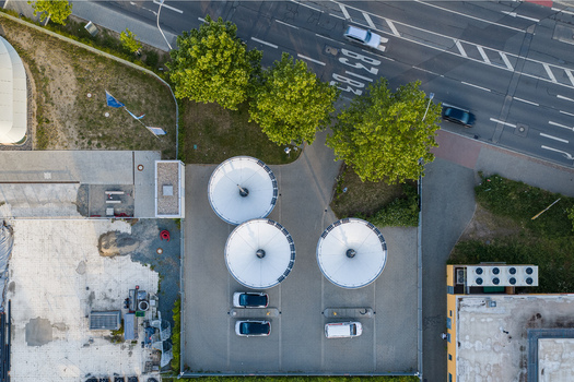 Aerial view of the ENTEGA Charging Station with three white solar umbrellas and parked cars in Darmstadt Hessen Germany. Aerial view of the ENTEGA Charging Station with three white solar umbrellas and parked cars in Darmstadt Hessen Germany.