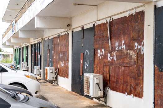 San Jose Tinian Northern Mariana Islands 05 July 2026 View of boarded up storefronts with plywood panels and air conditioning units along a street in San Jose. San Jose Tinian Northern Mariana Islands 05 July 2026 View of boarded up storefronts with plywood panels and air conditioning units along a street in San Jose.