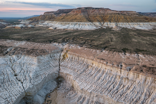 Aerial view of the dramatic white limestone cliffs and eroded canyons of the Tuzbair salt flats in the vast desert landscape of Mangystau District Mangystau Region Kazakhstan.