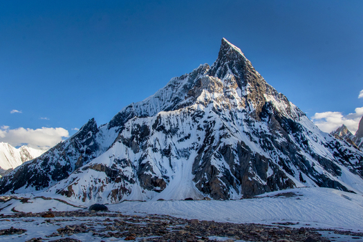 View of the towering snow covered Mitre Peak with its sharp triangular summit under a clear blue sky in the Karakoram range Skardu Gilgit Pakistan.
