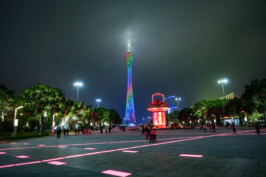Guangzhou Guangdong Province China 24 February 2024 View of the illuminated Canton Tower at night with festive decorations and people walking in the square. Guangzhou Guangdong Province China 24 February 2024 View of the illuminated Canton Tower at night with festive decorations and people walking in the square.