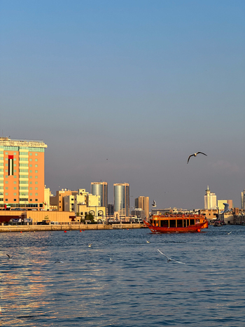 View of a traditional wooden abra boat sailing on Dubai Creek with the Bur Dubai skyline and modern buildings in the background Dubai Dubai United Arab Emirates. View of a traditional wooden abra boat sailing on Dubai Creek with the Bur Dubai skyline and modern buildings in the background Dubai Dubai United Arab Emirates.