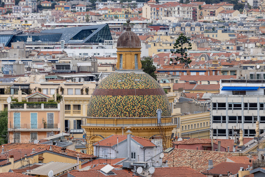 Aerial view of the colorful tiled dome of the Chapelle de la Misericorde surrounded by dense terracotta rooftops in the historic city center of Nice Provence Alpes Cote d Azur France. Aerial view of the colorful tiled dome of the Chapelle de la Misericorde surrounded by dense terracotta rooftops in the historic city center of Nice Provence Alpes Cote d Azur France.