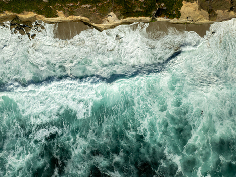 Aerial view of turquoise waves crashing against the sandy beach and rocky cliffs of La Jolla Cove San Diego California United States. Aerial view of turquoise waves crashing against the sandy beach and rocky cliffs of La Jolla Cove San Diego California United States.