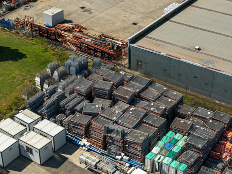 Kilsyth Victoria Australia 20 September 2026 Aerial view of industrial site featuring stacks of metal mesh crates portable office units and construction materials near a factory building. Kilsyth Victoria Australia 20 September 2026 Aerial view of industrial site featuring stacks of metal mesh crates portable office units and construction materials near a factory building.