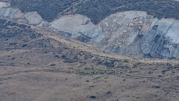 Aerial view of rugged rock formations and geological strata of a quarry featuring exposed stone layers sparse vegetation and dry terrain in Golden Colorado United States.