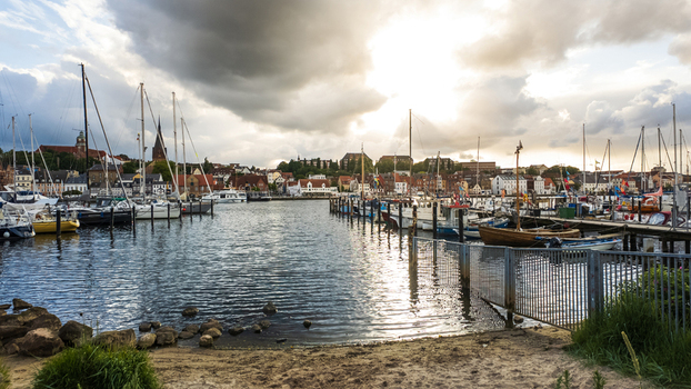 View of the historic harbor filled with sailboats and yachts under a dramatic cloudy sky in Flensburg Schleswig Holstein Germany. View of the historic harbor filled with sailboats and yachts under a dramatic cloudy sky in Flensburg Schleswig Holstein Germany.